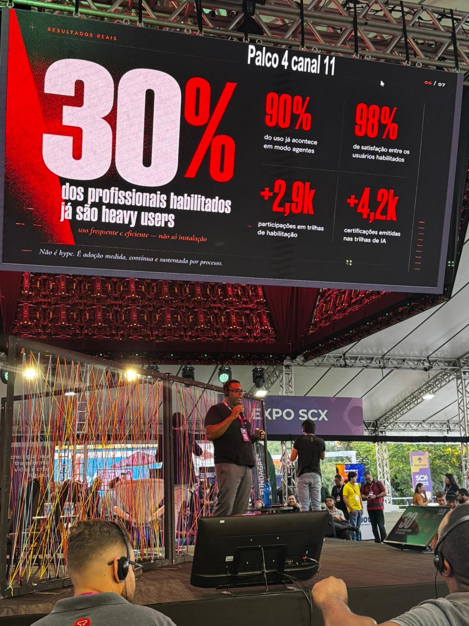 Palco e público acompanhando uma palestra de Jonathan Santos